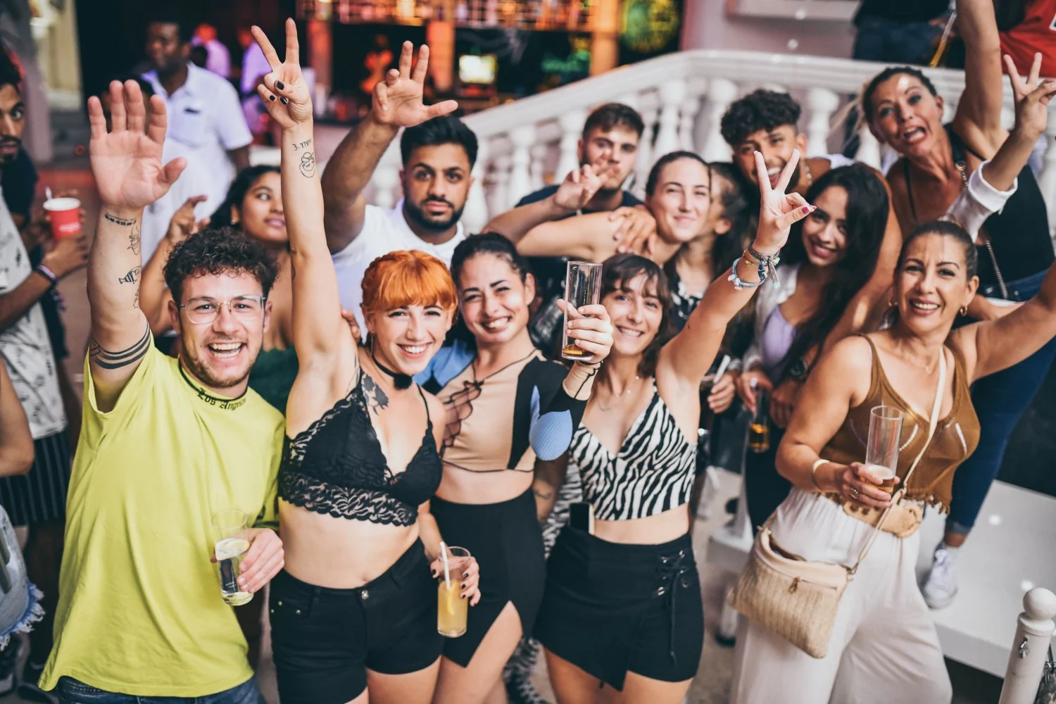 Friends partying at Es Paradis Ibiza, drinks in hand, big smiles and summer energy lighting up the dancefloor.