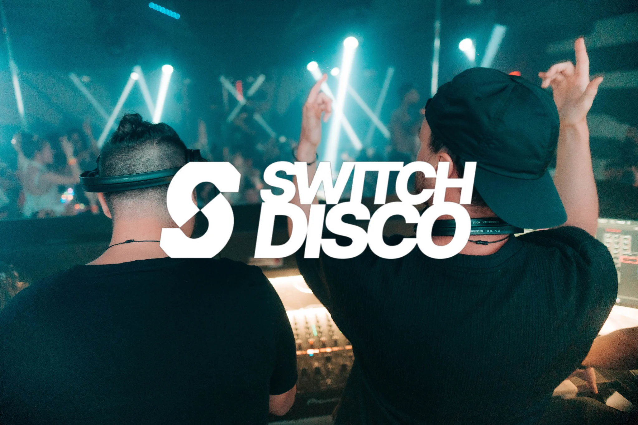 Switch Disco Malia with DJs hyping the crowd under neon lights, packed dancefloor and big summer party vibes.