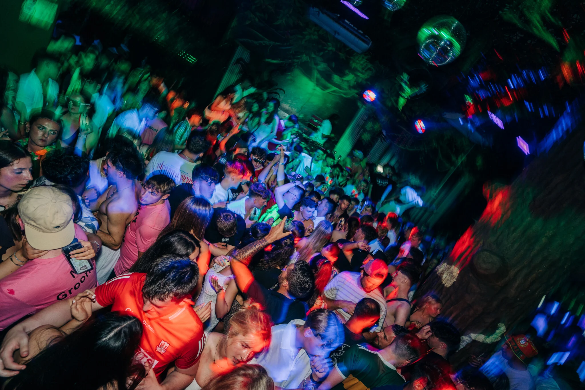 Crowd dancing under colourful lights at Club Tropicana Event Night in Albufeira, with a lively party atmosphere and packed dance floor.