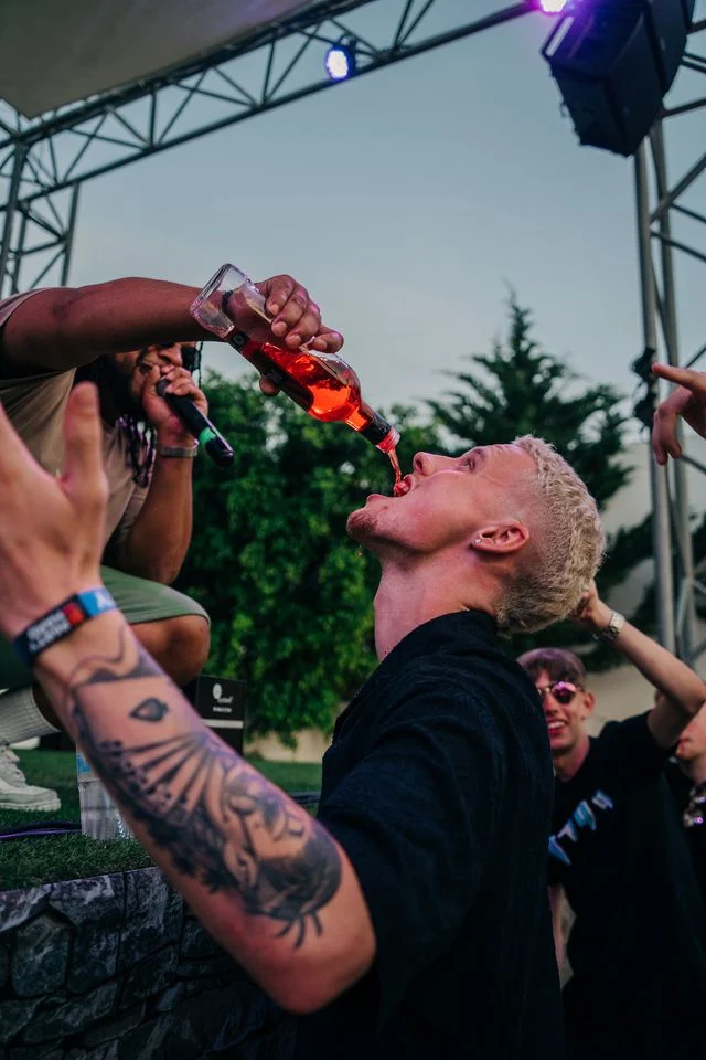 Performer pouring drinks down partygoer at Agenda Beach Club Party in Albufeira, keeping the summer energy alive.