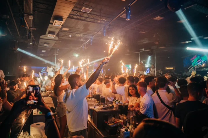 The White Party at Apollo Club in Malia going off — sparklers, packed dancefloor, drinks flowing and everyone dressed in white.