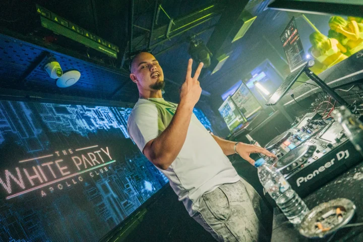 DJ on the decks at The White Party in Malia, dropping beats to a packed crowd ready for a massive night at Apollo Club.