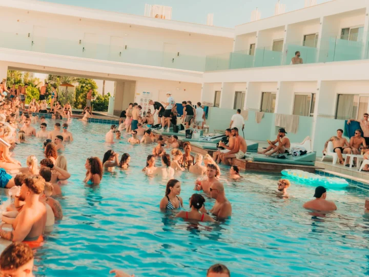 Ayia Napa pool party with crowds swimming, dancing and relaxing in the sun at a lively hotel venue