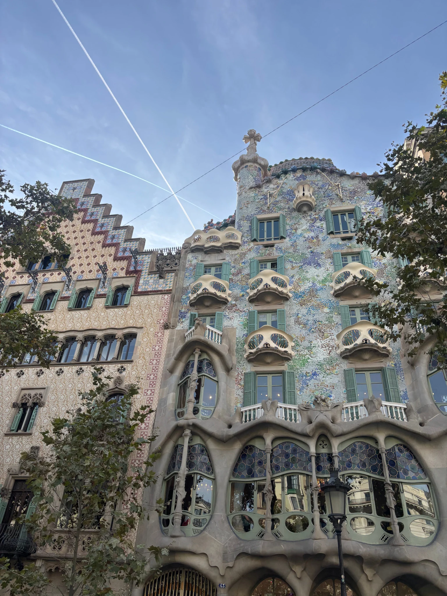 Colourful façade of Casa Batlló in Barcelona, with Gaudí’s surreal curves and mosaic design standing out under the clear sky.