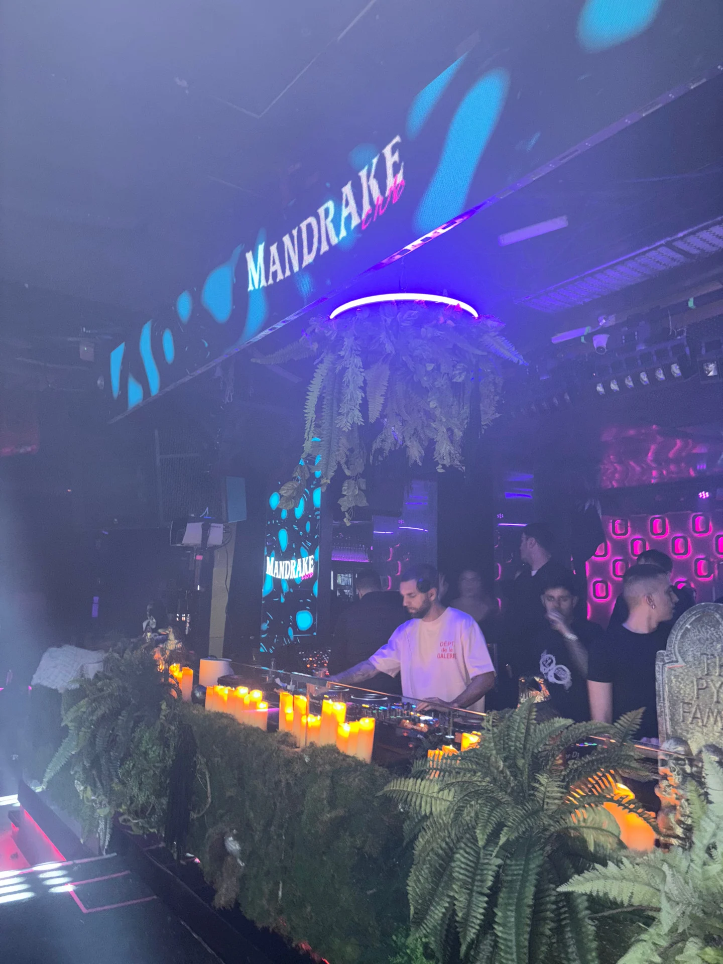 DJ at Mandrake Club, Barcelona working the decks as neon lights, candles and club décor build the atmosphere for a heavy late-night set.