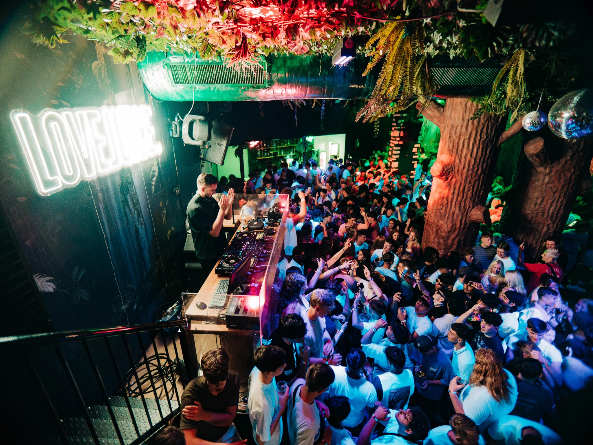 Packed Albufeira club crowd partying at Love Juice event under green and blue lighting